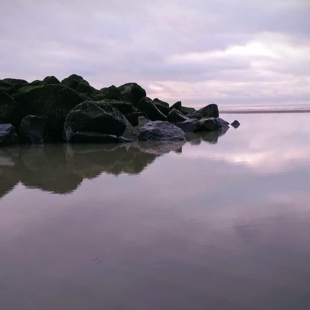 Zelfgemaakte foto van stenen in het water langs de kust.